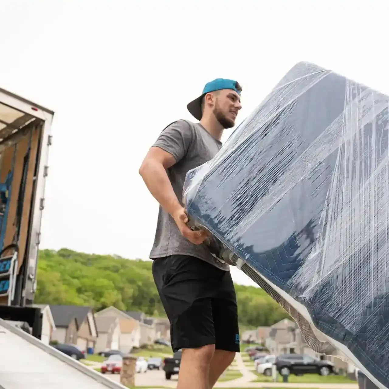 bek mover carrying wrapped furniture up ramp residential move BEK mover carrying wrapped furniture up ramp residential move