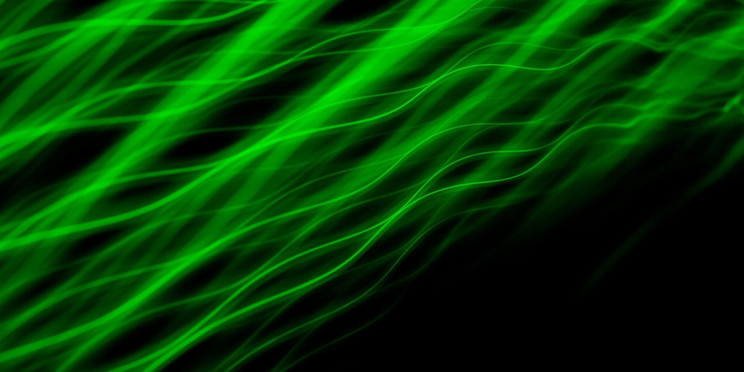 denis-sebastian-tamas-4YdAsyI9j3A-unsplash Abstract green light streaks on black background