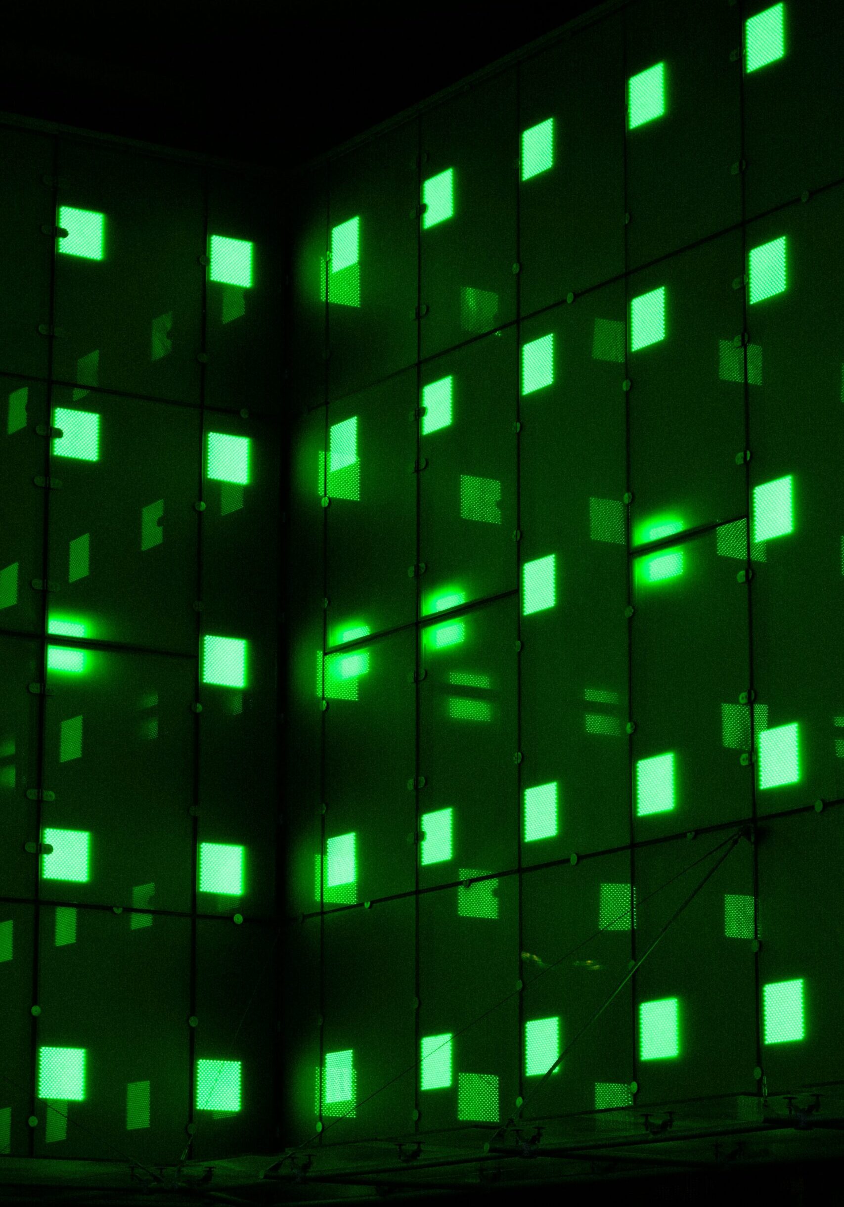mathias-reding-Fm5dF5vYgfU-unsplash Green illuminated grid pattern on building facade